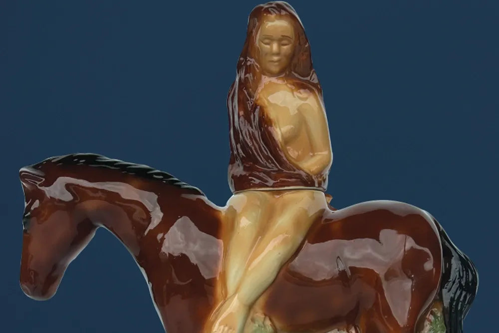 A glazed vintage decanter shaped like a long-haired rider on a brown horse.