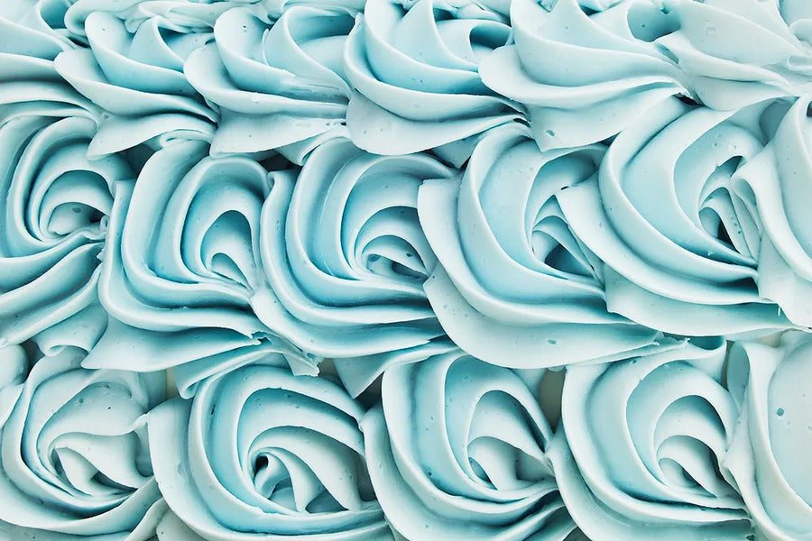 Rows of pale blue buttercream rosettes piped across a cake.