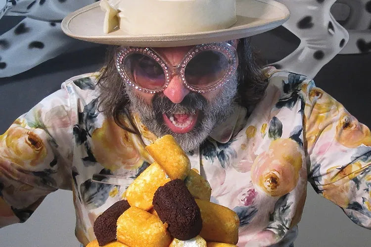 A close crop of a person in a cream hat reacting to a stack of snack cakes.