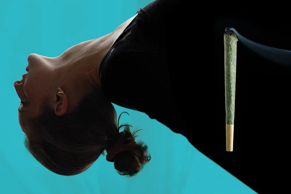 A person arches backward with a joint balanced upright against their black shirt.