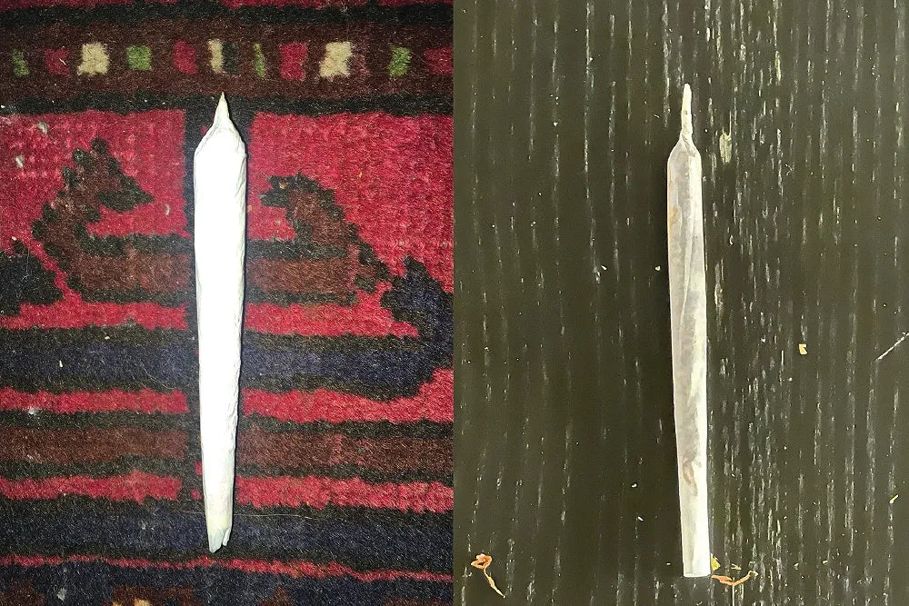 Two joints on a red patterned rug and a green wooden surface.