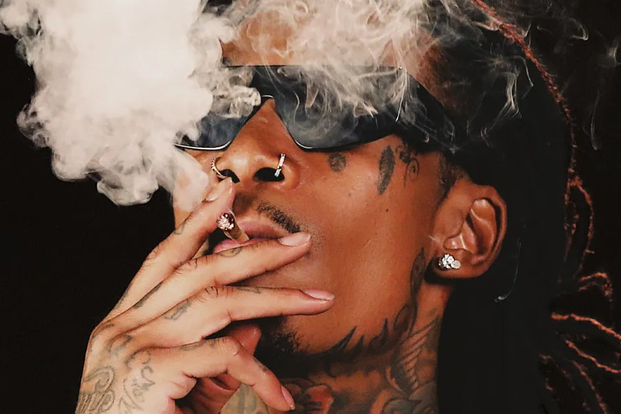 A close-up of Wiz Khalifa's face surrounded by drifting smoke.